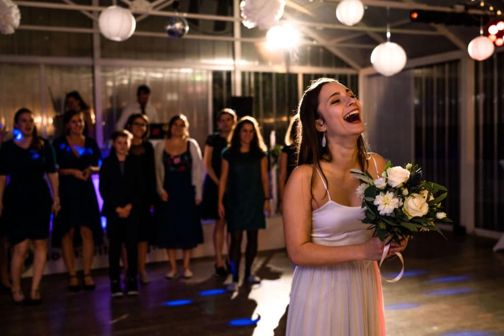 Hochzeitsfotograf hat ein Hochzeitsfoto gemacht auf dem eine Braut ihren Brautstrauß wirft
