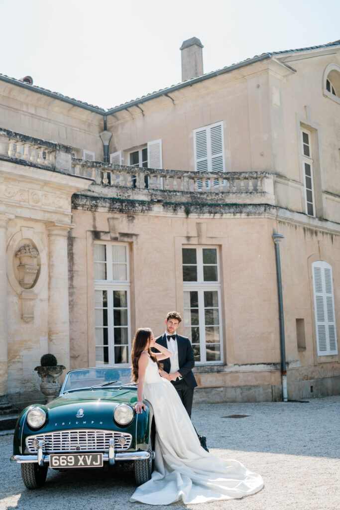 Brautpaar vor einem Oldtimer vor einem Schloss