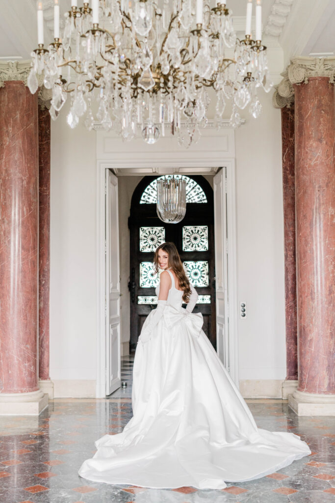 Braut in Bewegung in weißem Brautkleid dreht sich lächelnd um